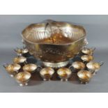 A silver plated punch bowl with cups and ladle