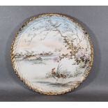 A Japanese porcelain large dish decorated with a cockerall amongst foliage with mountains in the