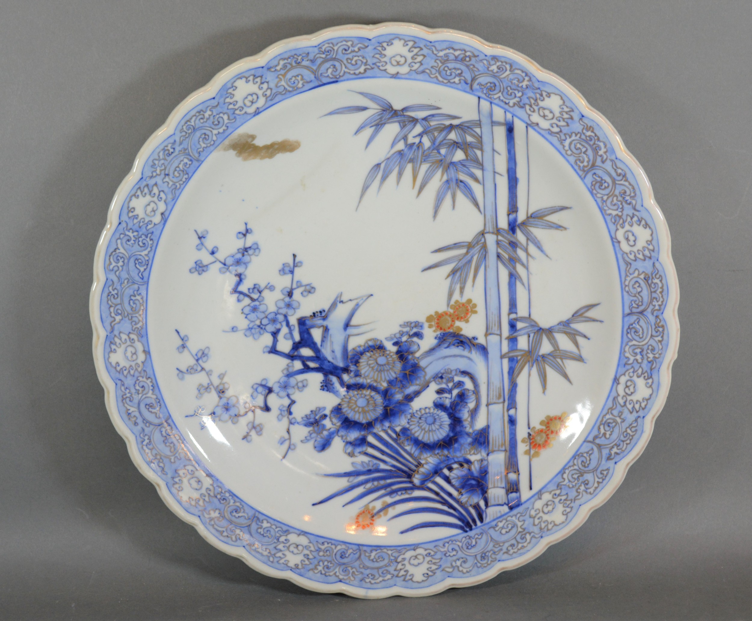 A Japanese porcelain charger decorated in under glaze blue and highlighted with gilt, 41cms diameter