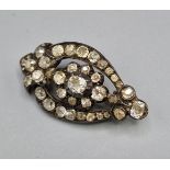 An early 19th Century diamond set brooch with a central diamond surrounded by diamonds, 3.5cms long,