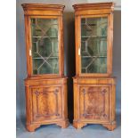 A pair of mahogany standing corner cabinets, each with a moulded cornice above an astragal glazed