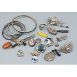 A collection of jewellery to include brooches, bangles and silver charms