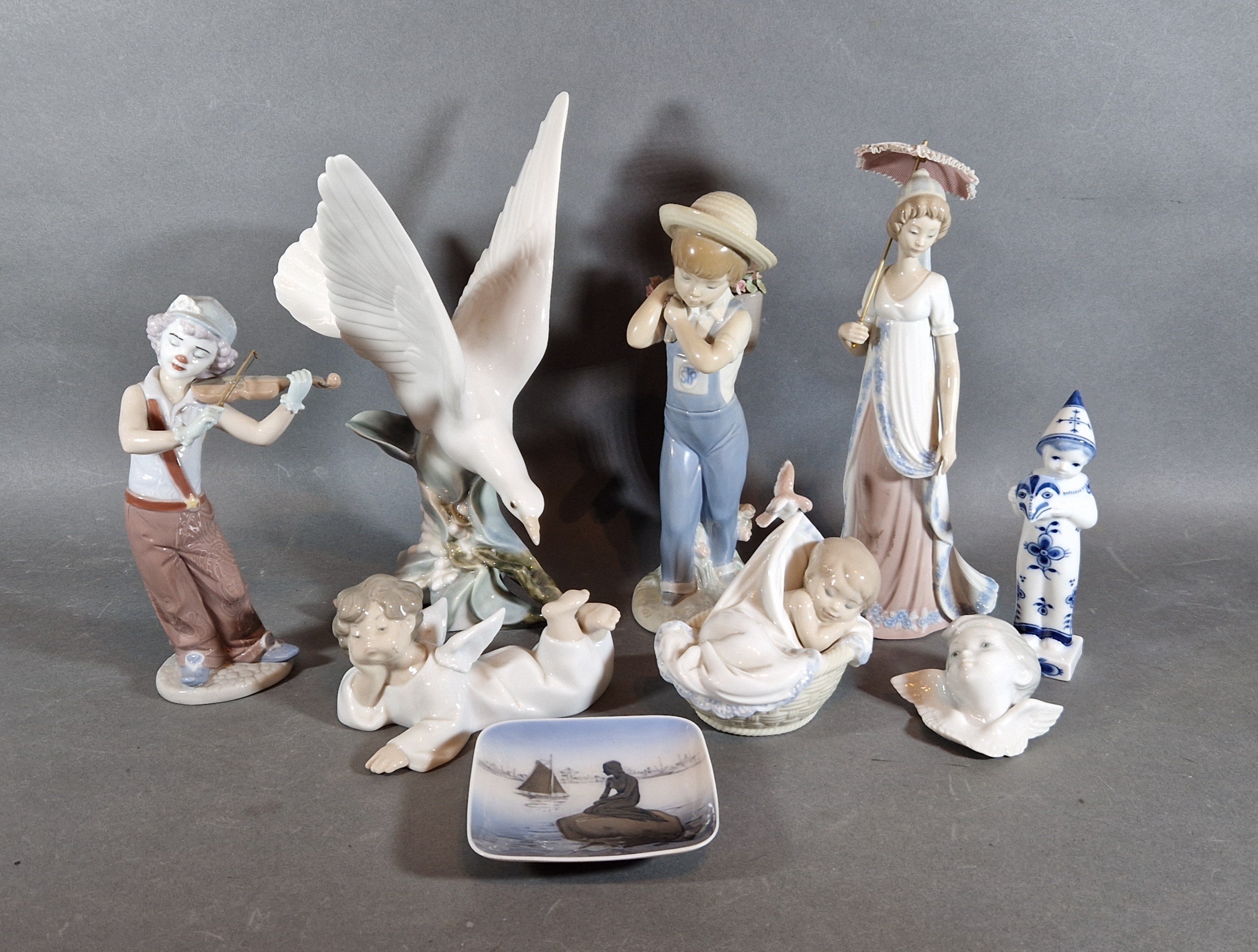 A Lladro porcelain model in the form of a bird together with six other Lladro porcelain models and a