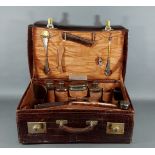 An early 20th Century Aligator skin travelling case with five silver topped and glass dressing