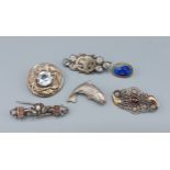 A collection of six silver brooches to include a filigree garnet mounted brooch