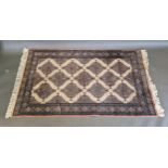 A Karachi woollen rug with an all-over design upon a pale ground within multiple borders, 157cms x