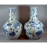 A pair of Chinese underglaze blue decorated bottle neck vases each decorated with carp amongst