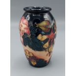 A Moorcroft Oberon pattern small vase, tube lined upon a blue ground, 11cms tall