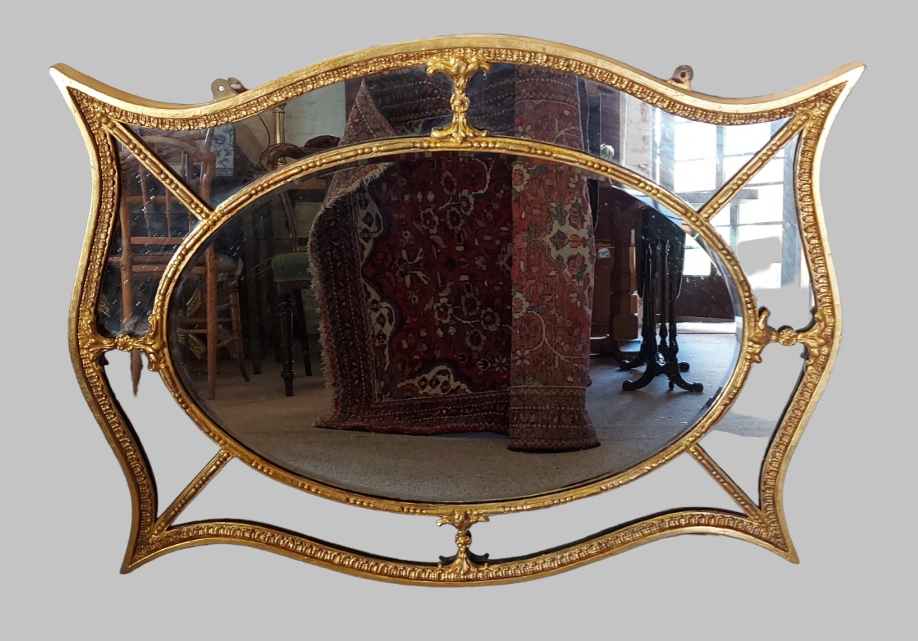 A gilt framed wall mirror of shaped sectional form, 81cms x 101cms