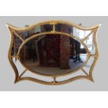 A gilt framed wall mirror of shaped sectional form, 81cms x 101cms