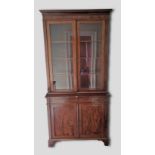 A Victorian mahogany bookcase, the moulded cornice above two glazed doors, the lower sction with two