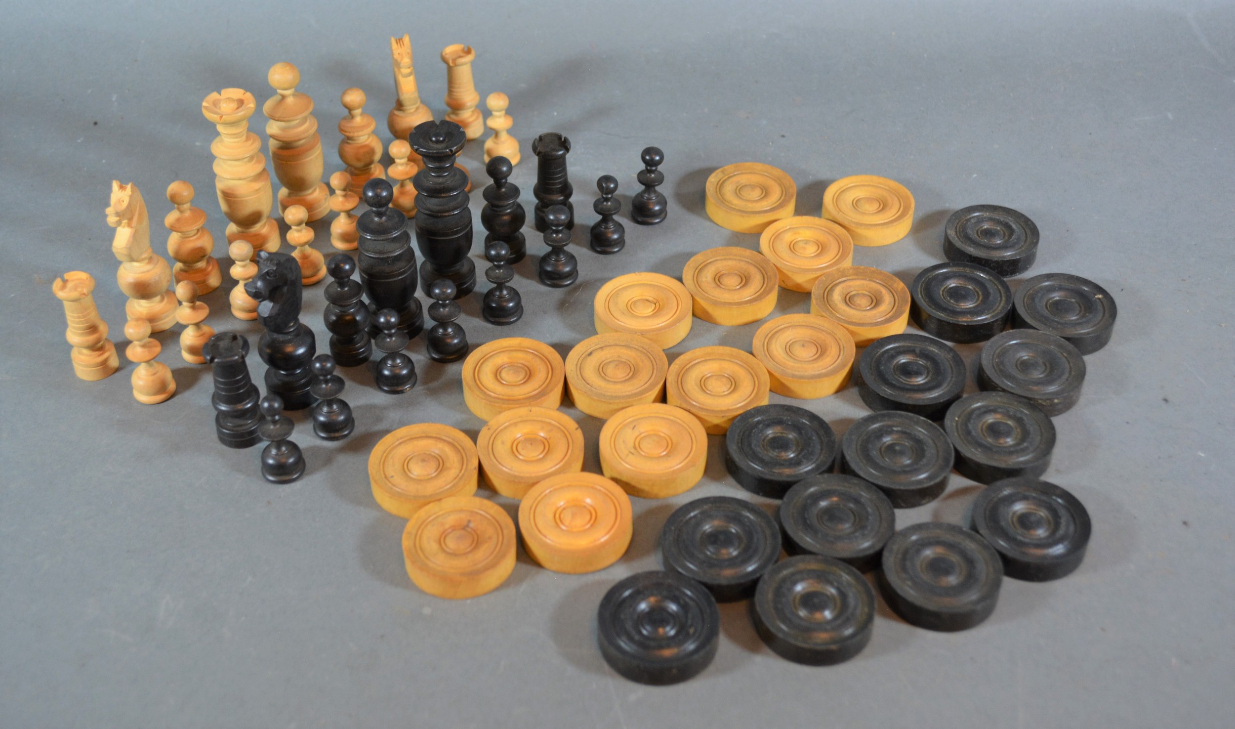 A boxwood and ebonised chess set together with a set of draughts