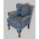 A Queen Anne style wingback armchair with shell carved cabriole legs and pad feet