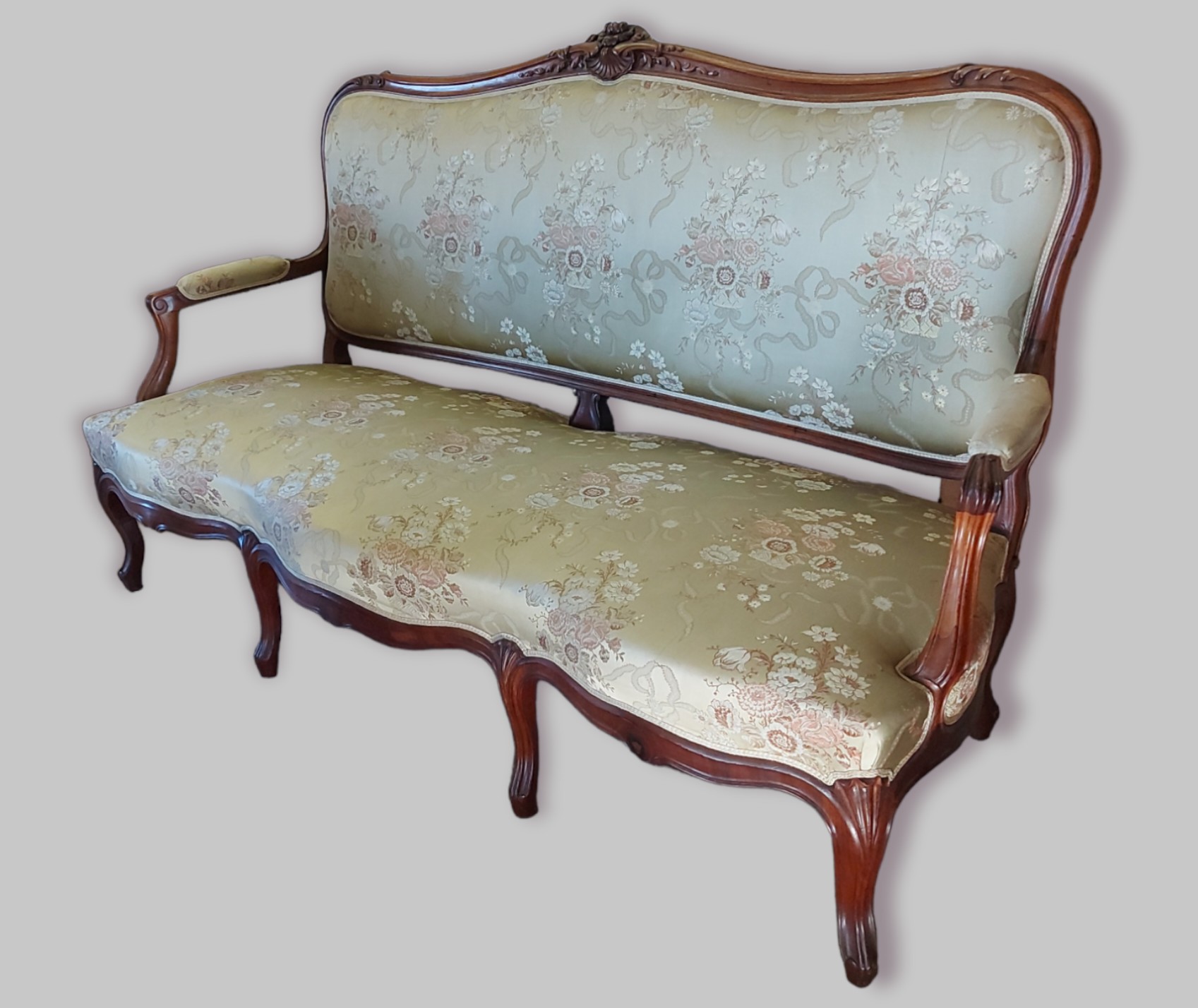 A French rosewood sofa, the shaped carved and upholstered back above a similar seat with carved