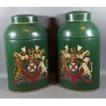 A pair of toleware cannisters each decorated with a crest upon a green ground, 45cms tall
