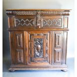 An Oak Court Cupboard with two moulded doors above a central moulded and carved door, raised upon