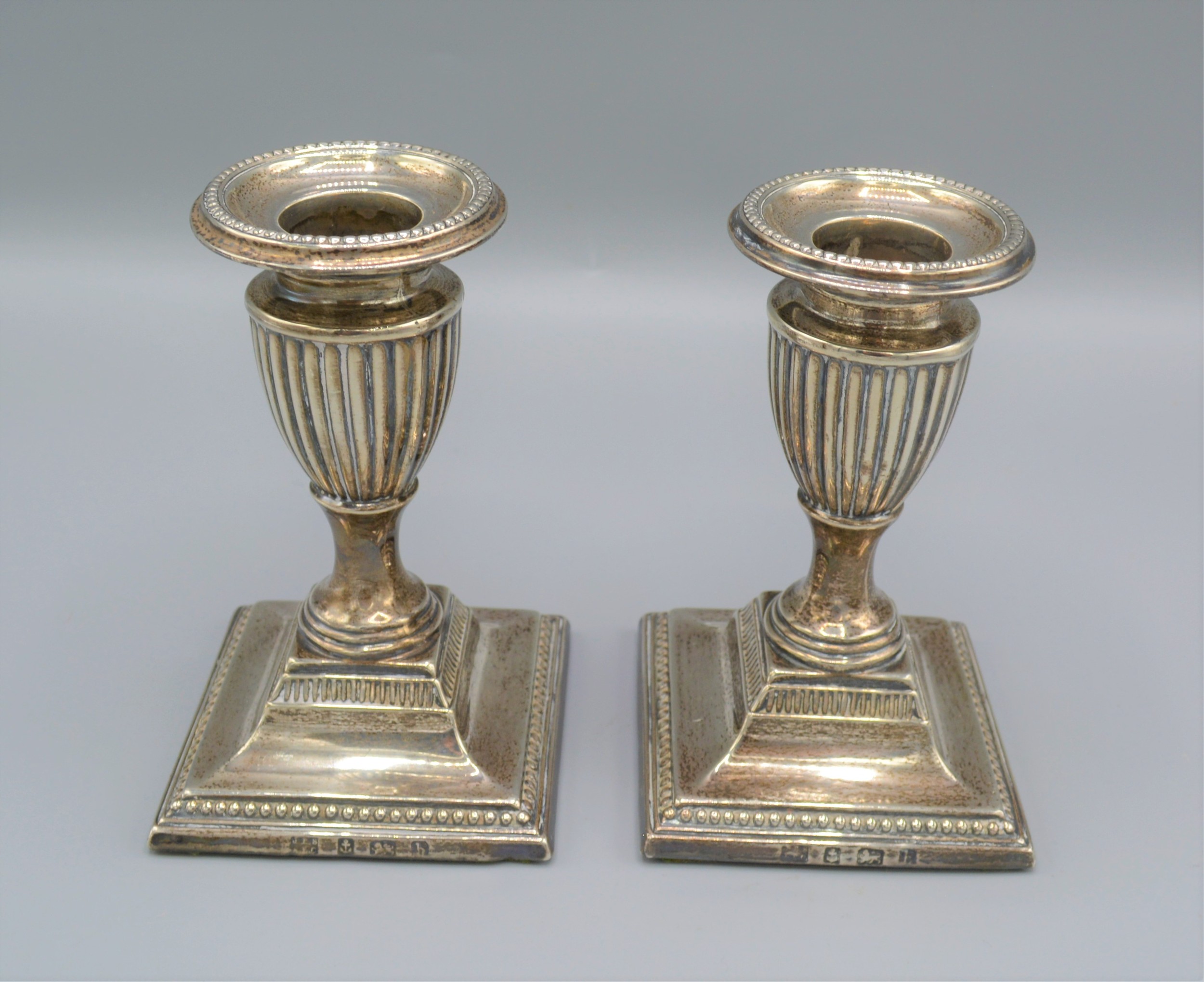 A pair of Birmingham silver dwarf candlesticks with square bases, 12cms tall