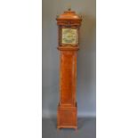 A 19th Century oak long case clock the rectangular hood with brass finials above a rectangular door,