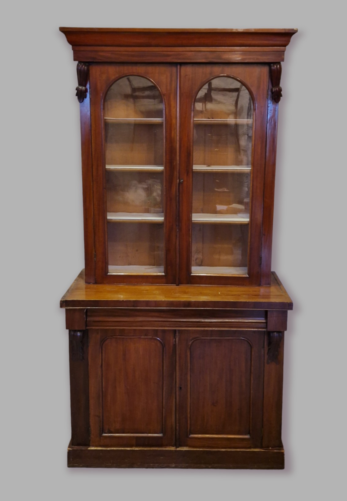 A Victorian mahogany bookcase, the moulded cornice above two glazed doors enclosing shelves, the