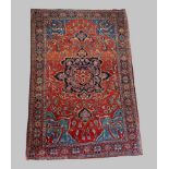 A North West Persian woollen rug with a central medallion within an all over design upon a red, blue