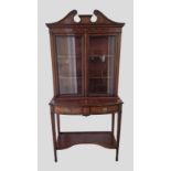 An Edwardian mahogany marquetry inlaid bookcase, the inlaid cornice with swan neck pediment above