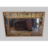 A gilt framed cushion mirror of sectional form, 51cms x 77cms