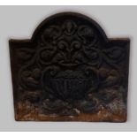 A cast iron fire back with foliate decoration, 50cm by 52cm