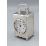 A silver cased table clock by Asprey, with carrying handle upon low feet, London 1985, 7cms tall