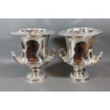 A pair of silver plated wine coolers, each with side handles upon pedestal bases, 28cms tall