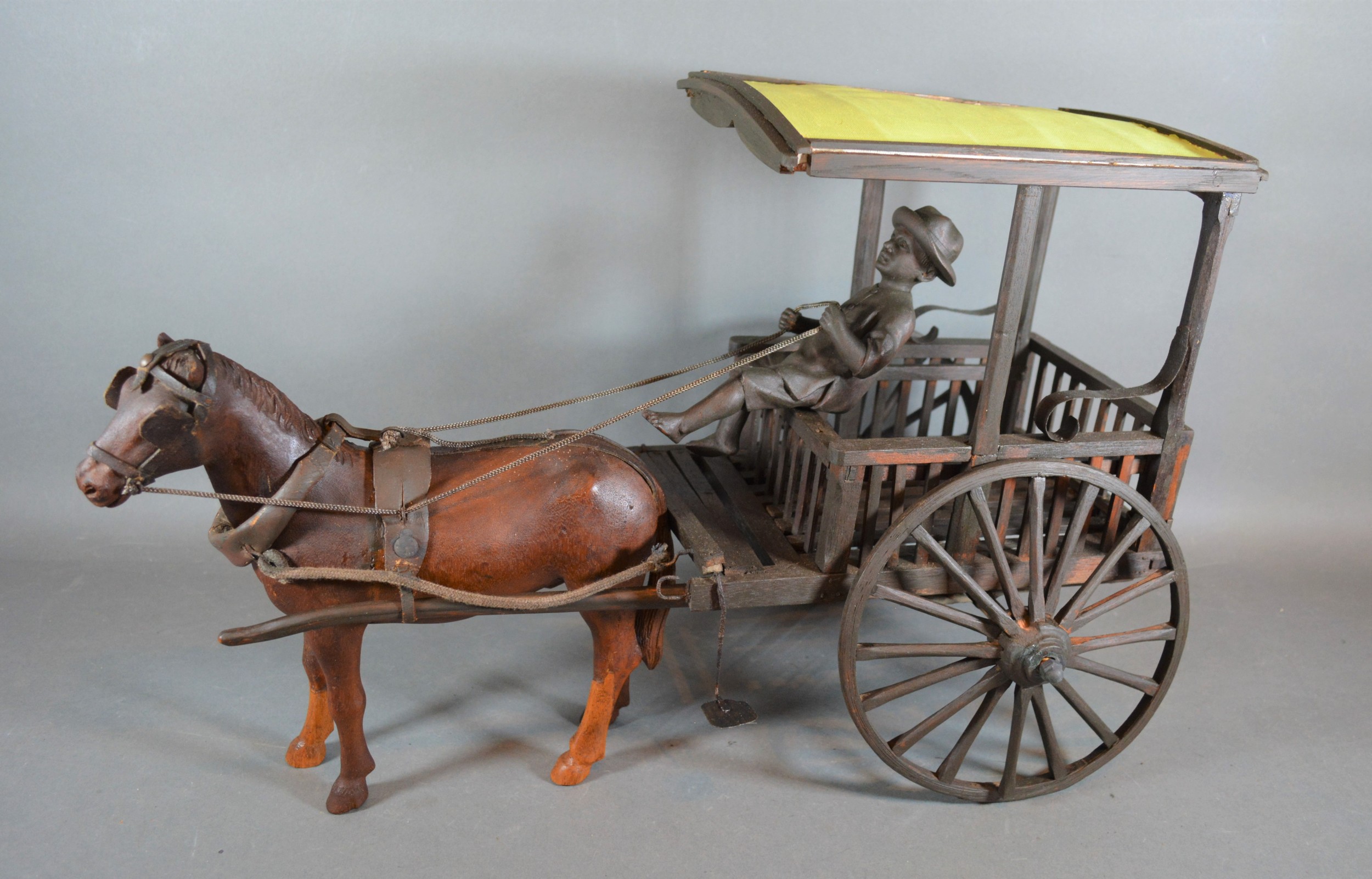 A wooden model in the form of a horse and cart with figure, 52cms long