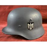 German WWII Stahlhelm helmet which has been repainted and had decals added, with chin strap, the