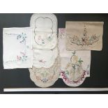 Mixed collection of pretty floral embroidered tray cloths, mats and pyjama case, mostly linen, 1900-