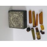 SILVER TOPPED BOX, Decorated figures containing a selection of amber cheroot holders