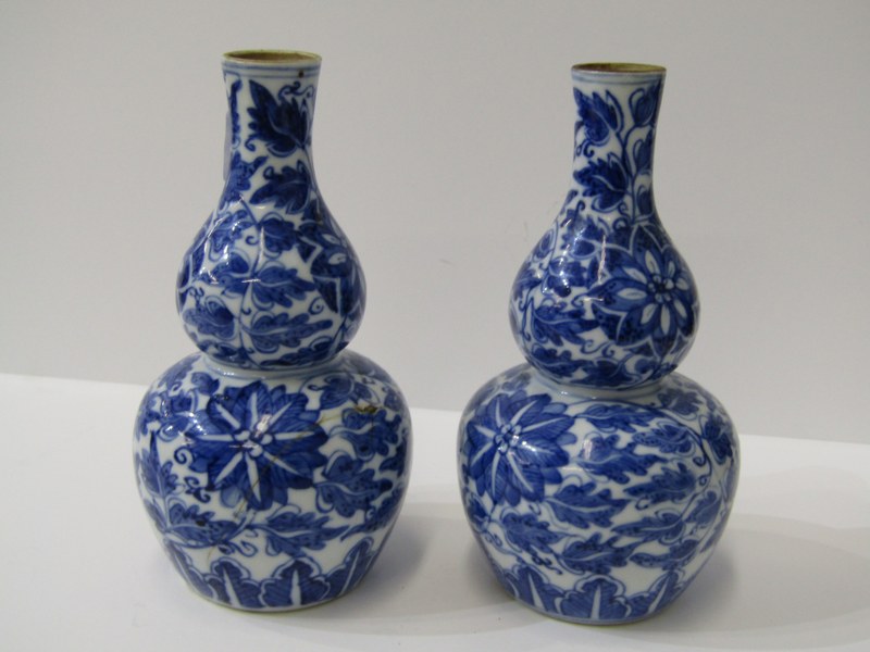 EASTERN CERAMICS, pair of underglaze blue double gourd 16cm vases decorated with busy floral design,