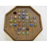 MARBLES, oak octagonal solitaire board containing 33 coloured marbles