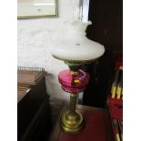 ANTIQUE OIL LAMP, brass column base cranberry glass reservoir oil lamp with milk glass shade