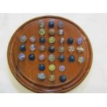 MARBLES, walnut circular solitaire board containing 33 marbles including 10 blue micas