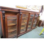 VICTORIAN MAHOGANY BREAK FRONT GLAZED BOOKCASE, 4 doors with carved bracket supports, 256 cm width