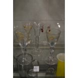 A pair of small gilt decorated and engraved wine glasses with double knop stems together with an