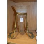 A brass stand containing a conical glass vase.