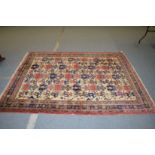 A Persian carpet, cream ground with stylized motifs.