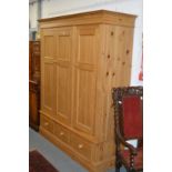 A good modern pine three door wardrobe with three drawers to the base.