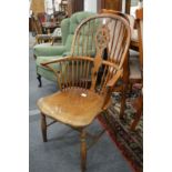 A 19th century ash, yew and elm wheel back Windsor armchair.