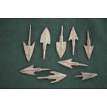 Nine small metal arrowheads, various sizes.