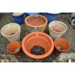 Seven various terracotta garden planters.