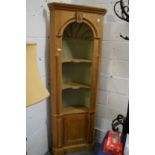 A classical style pine standing corner cabinet with barrel back and cupboard door to the base.