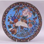 A JAPANESE CLOISONNE CIRCULAR DISH, decorated with cranes amongst native flora, 30.5cm diameter.