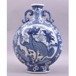 A LATE 19TH CENTURY BLUE AND WHITE TWIN HANDLE PORCELAIN MOON FLASK, the centre painted with kylin