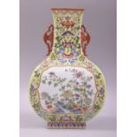 A CHINESE FAMILLE VERTE TWIN HANDLE SQUARE FORM BALUSTER VASE, decorated with two panels of native