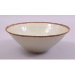 A CHINESE CELEDON GLAZED INCISED BOWL, the interior with carved floral decoration, 19.5cm diameter.